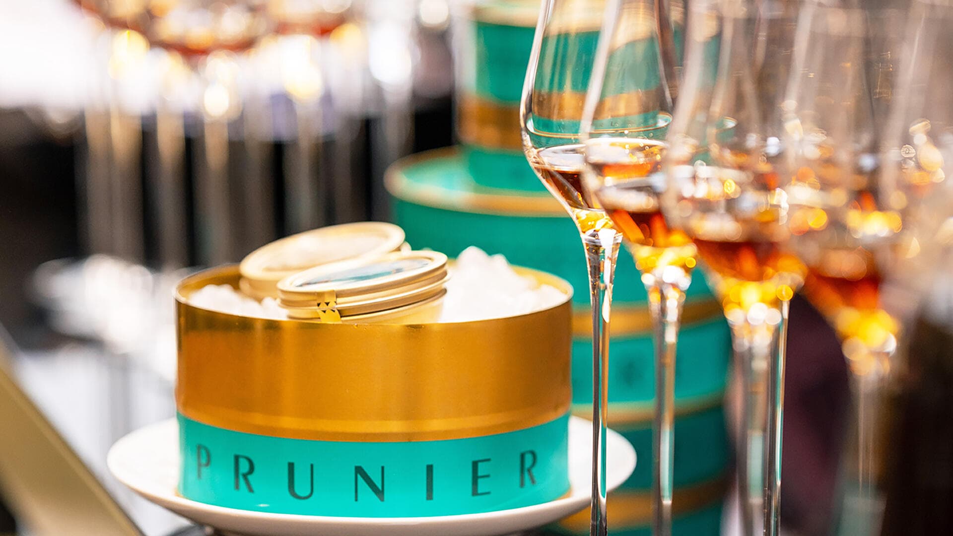 Tin of Prunier Paris Oscietra Caviar alongside glasses of Hennessy cognac