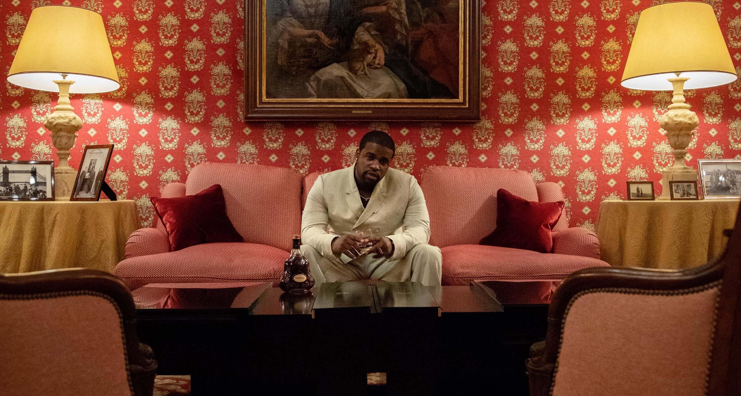 A$AP Ferg relaxing after dinner on a couch in the Hennessy Maison, with a glass of Hennessy X.O cognac.