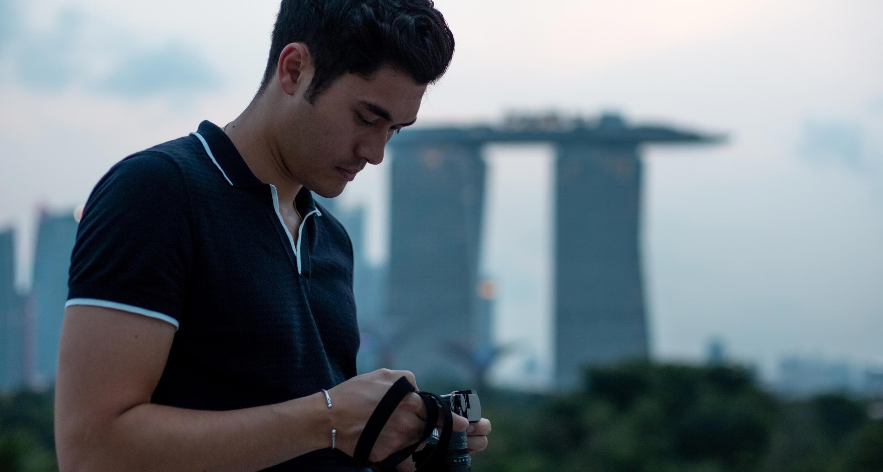 Henry Golding taking photographs in Singapore.