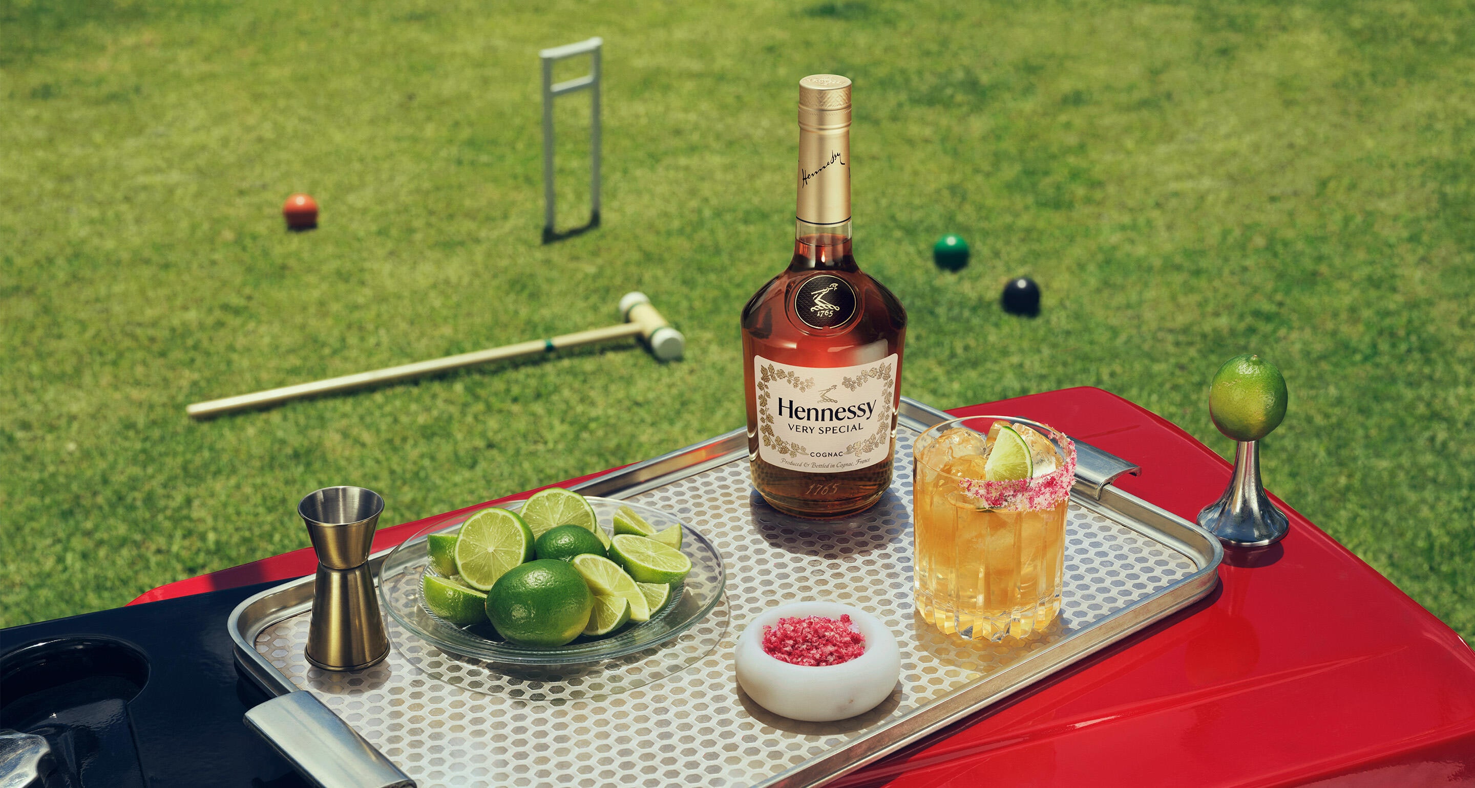 Sparkling Hennessy V.S bottle and HENNY RITA™ on a stylish tray set on the lawn.