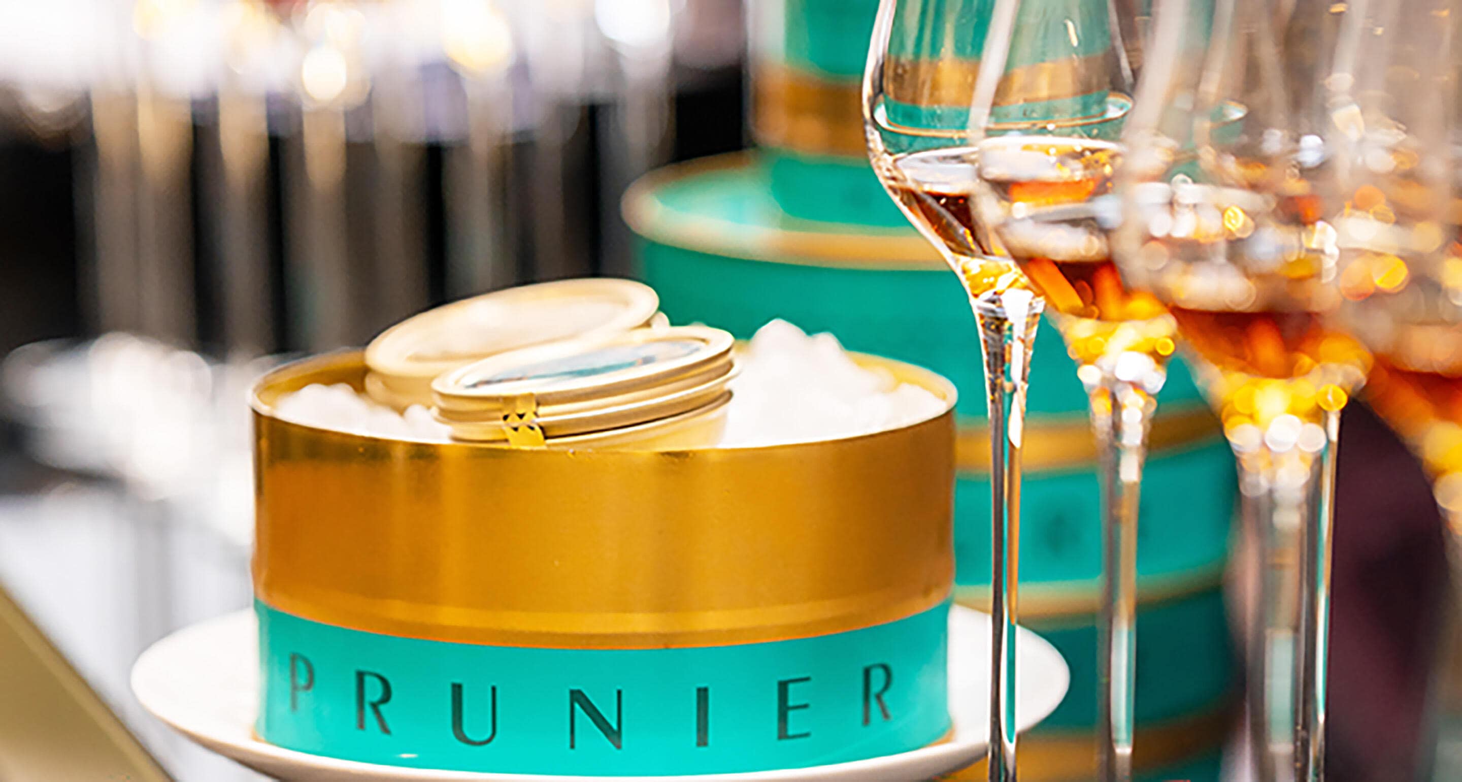 Tin of Prunier Paris Oscietra Caviar alongside glasses of Hennessy cognac