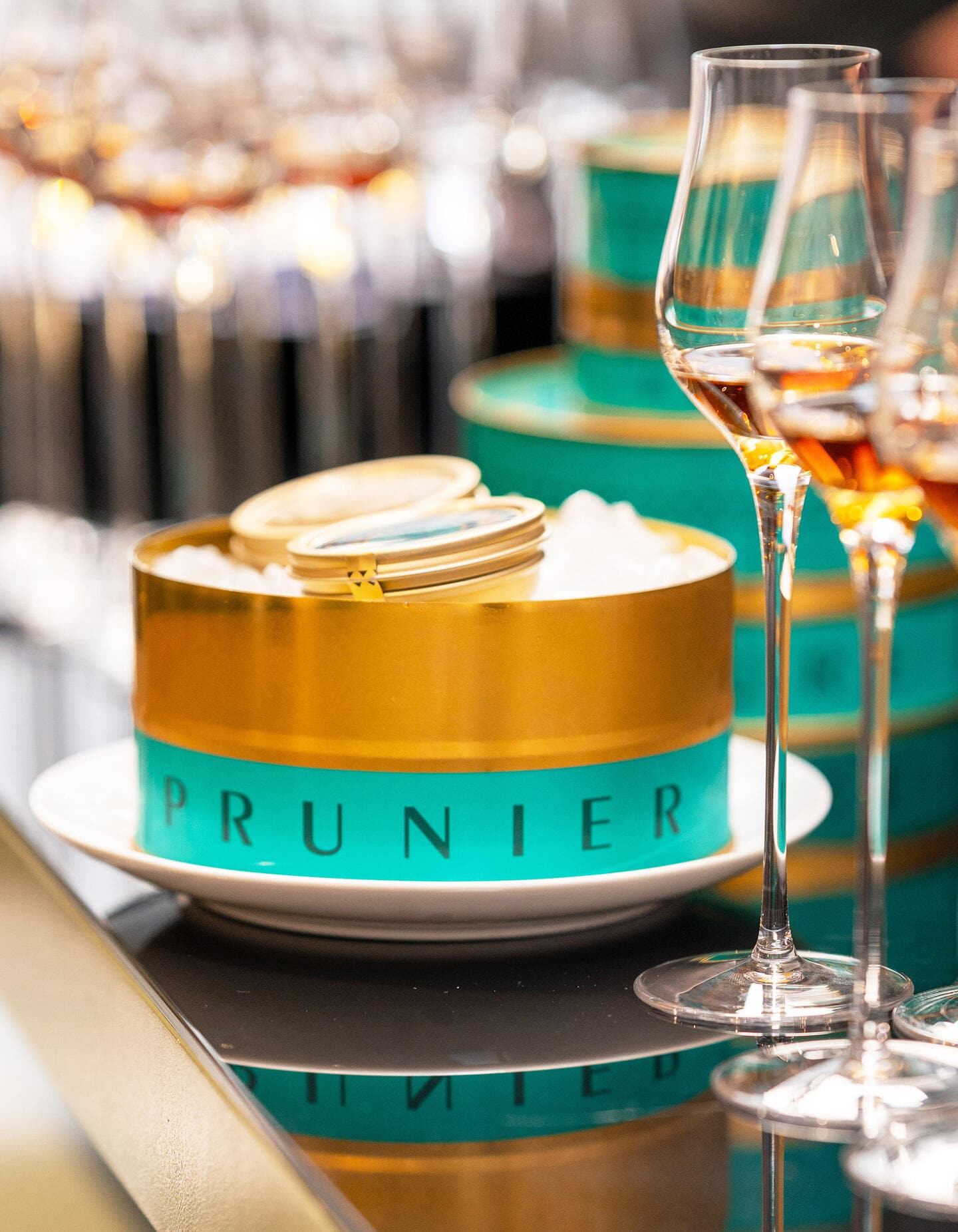 Tin of Prunier Paris Oscietra Caviar alongside glasses of Hennessy cognac