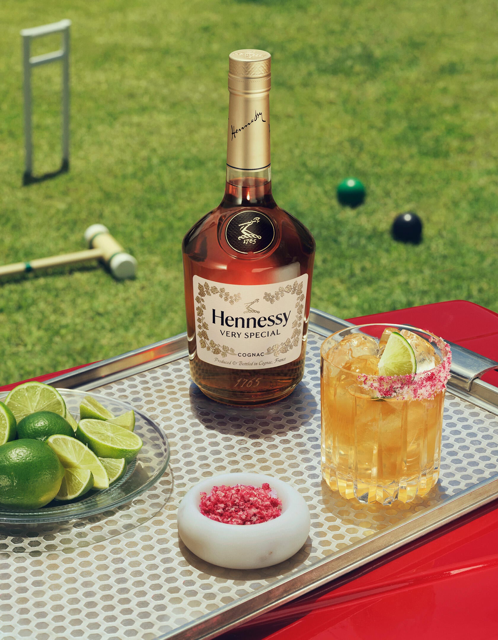 Sparkling Hennessy V.S bottle and HENNY RITAâ„¢ on a stylish tray set on the lawn.