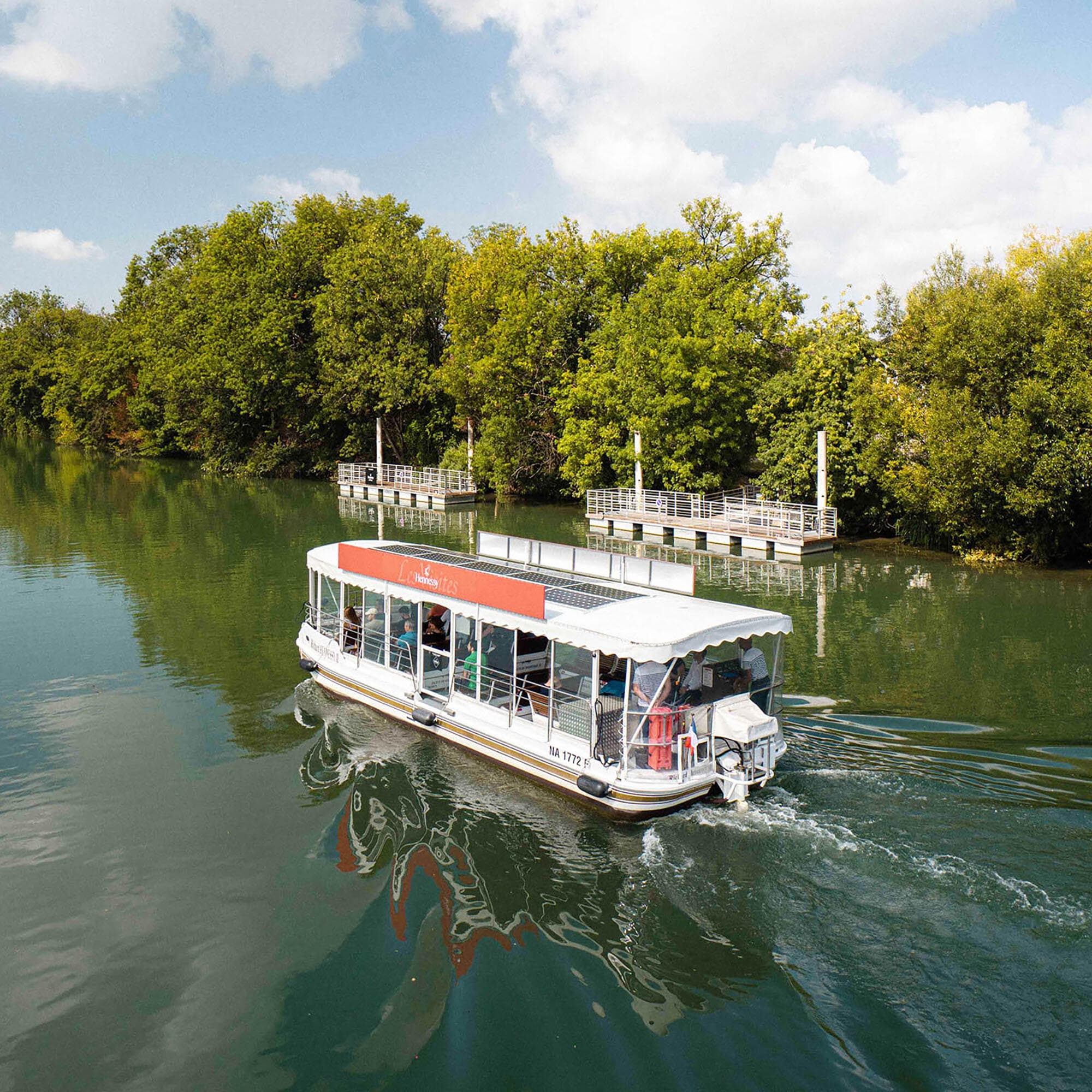 Hennessy solar-powered boat cruising along the Charente River in Cognac